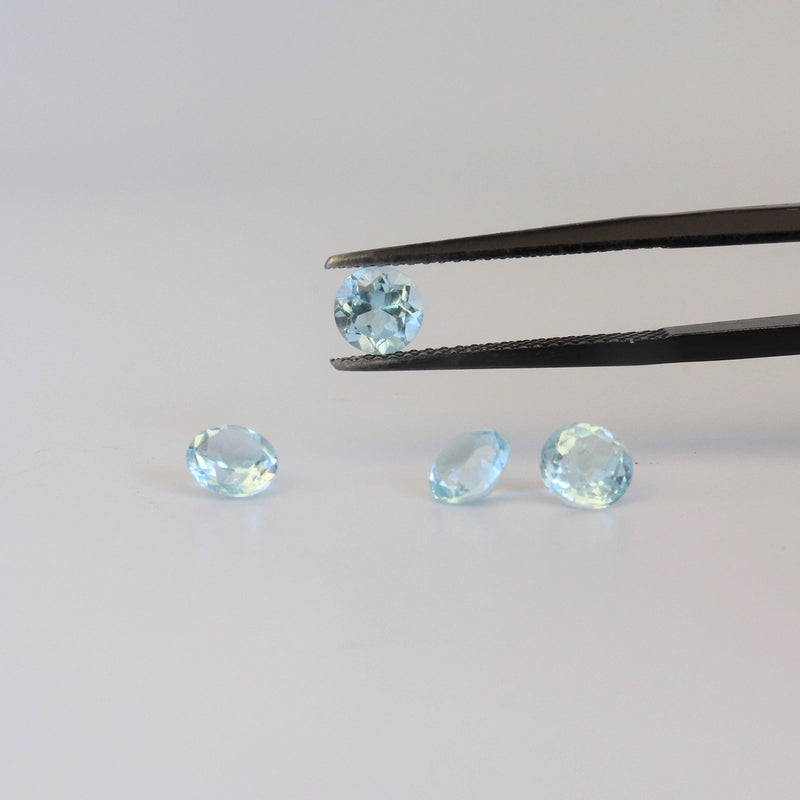 5.1mm Round Blue Topaz With tweezer view - cape diamond exchange 