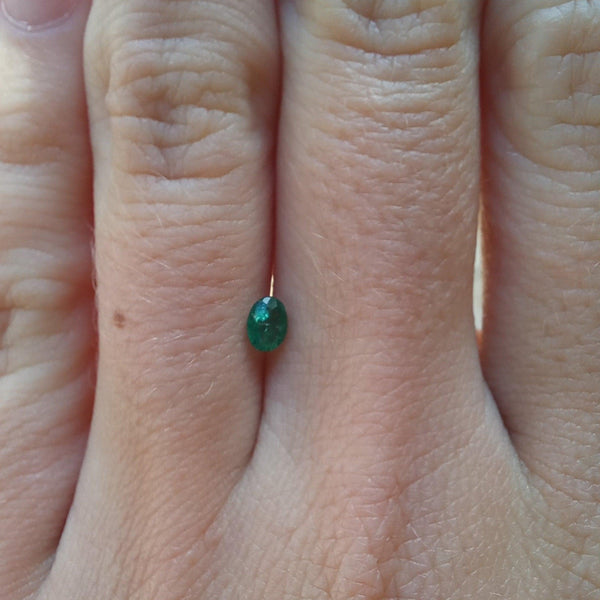0.21ct Oval Emerald Stone with finger view - cape diamond exchange