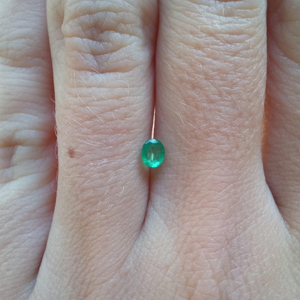 0.23ct Oval Emerald Stone with finger view - cape diamond exchange