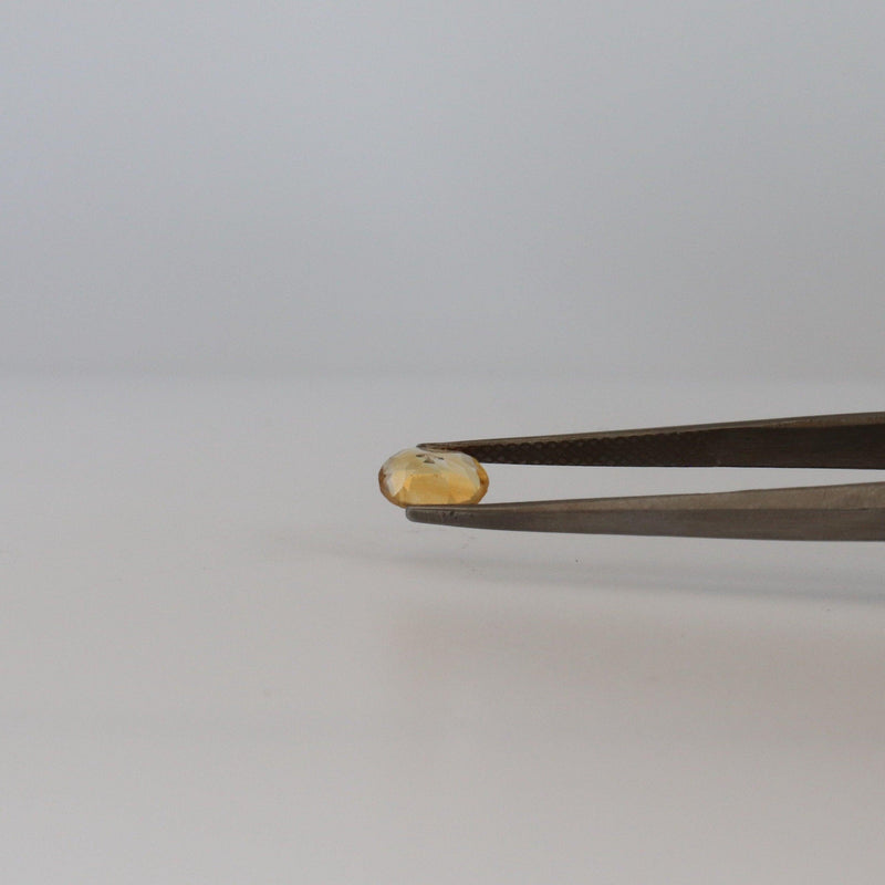 4.7mmx6.9mm oval citrine stone with tweezer view - cape diamond exchange